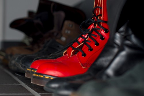 De røde støvler Røde Doc Martens i en række af sorte sko